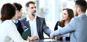 happy business people closing deal shaking hands